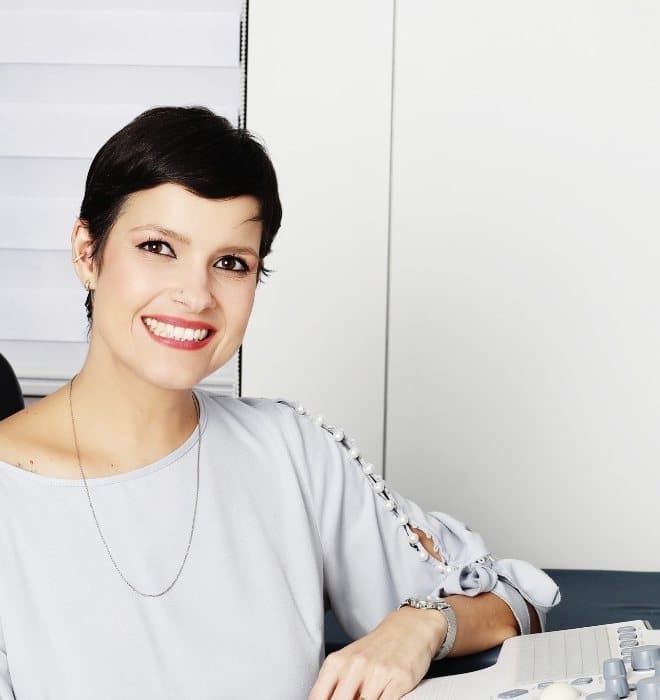 Dra. Michelle Sanches sorrindo no consultório